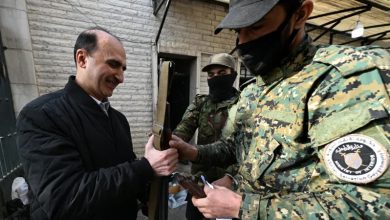 جندي تابع لحكومة الإنقاذ يتسلم أسلحة في أحد مكاتب حزب البعث بدمشق